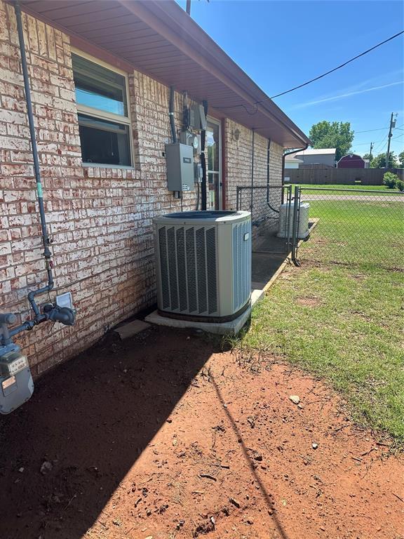 1721 E Ridgeview Ter, Mustang, OK 73064 - details featuring brick siding, cooling unit, and fence