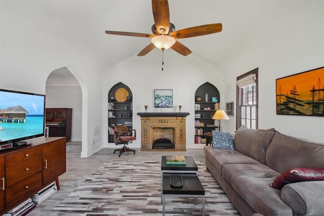 1912 NW 22nd St, Oklahoma City, OK 73106 - living room with wood finished floors, built in shelves, a ceiling fan, a fireplace, and vaulted ceiling