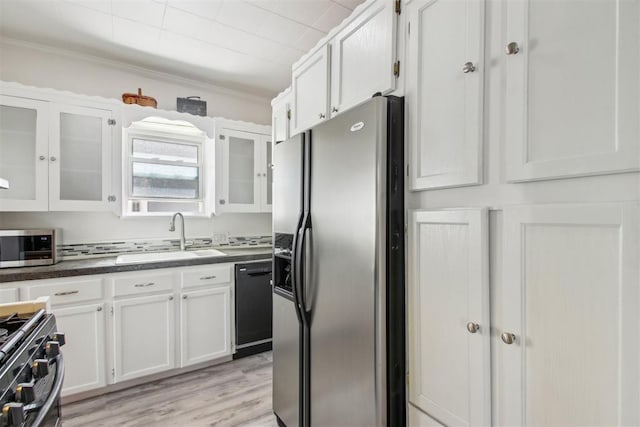1912 NW 22nd St, Oklahoma City, OK 73106 - kitchen featuring stainless steel appliances, white cabinets, dark countertops, glass insert cabinets, and crown molding