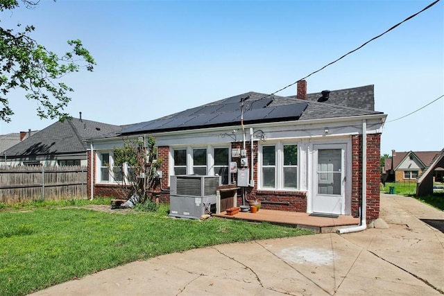 1912 NW 22nd St, Oklahoma City, OK 73106 - back of house with brick siding, roof mounted solar panels, and a chimney