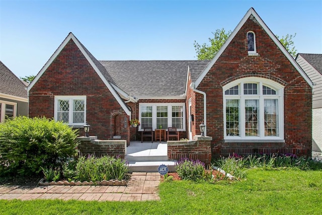 1912 NW 22nd St, Oklahoma City, OK 73106 - view of front of property with brick siding, a shingled roof, and a patio