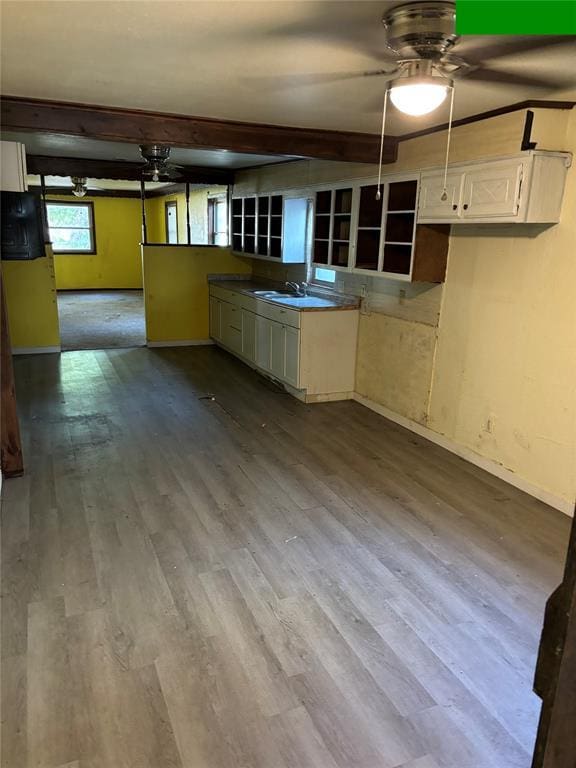 kitchen featuring ceiling fan, open shelves, a sink, dark wood finished floors, and baseboards