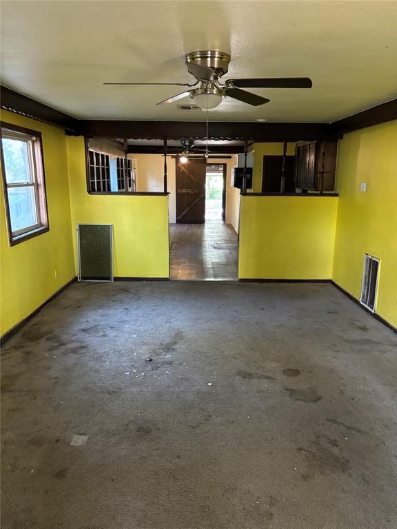 unfurnished living room with baseboards and ceiling fan