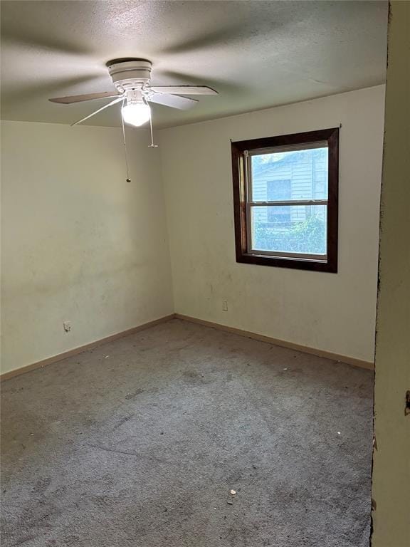 carpeted spare room with a ceiling fan, a textured ceiling, and baseboards