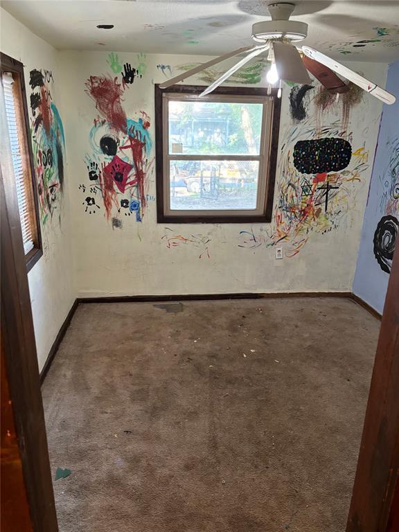 spare room with baseboards, plenty of natural light, ceiling fan, and carpet