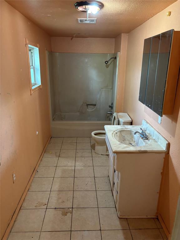 bathroom with visible vents, tile patterned floors, vanity, toilet, and washtub / shower combination