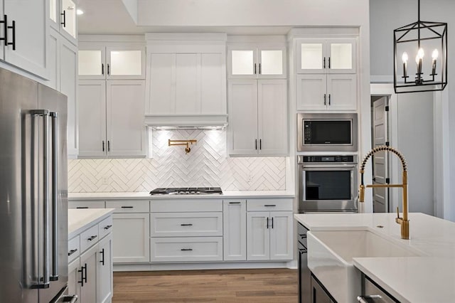 2217 Winter Creek Blvd, Blanchard, OK 73010 - kitchen with light countertops, white cabinetry, a sink, backsplash, and stainless steel appliances