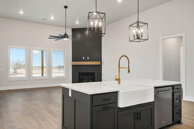 2217 Winter Creek Blvd, Blanchard, OK 73010 - kitchen featuring a sink, light countertops, a large fireplace, ceiling fan with notable chandelier, and open floor plan