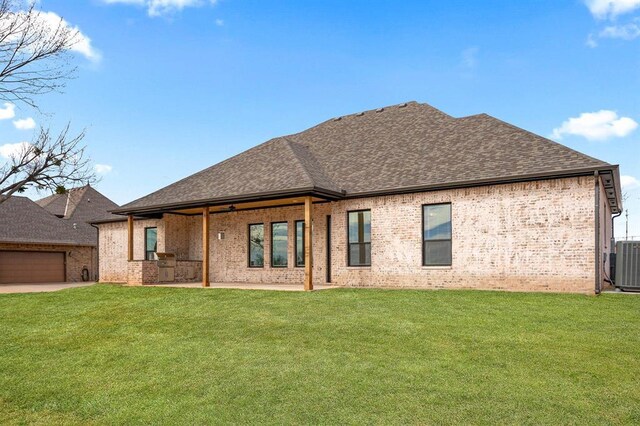 2217 Winter Creek Blvd, Blanchard, OK 73010 - back of house with brick siding, a shingled roof, and a yard