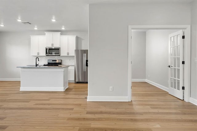 kitchen with baseboards, recessed lighting, white cabinets, appliances with stainless steel finishes, and backsplash