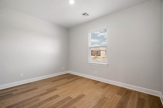 unfurnished room featuring baseboards, visible vents, and light wood-type flooring