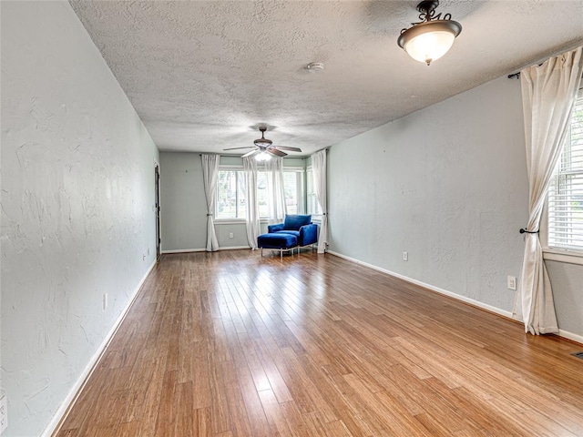 2429 Barclay Rd, Oklahoma City, OK 73120 - unfurnished room featuring a textured wall, a textured ceiling, ceiling fan, wood finished floors, and plenty of natural light