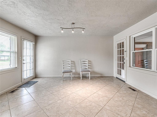 2429 Barclay Rd, Oklahoma City, OK 73120 - unfurnished dining area featuring tile patterned floors and a textured ceiling