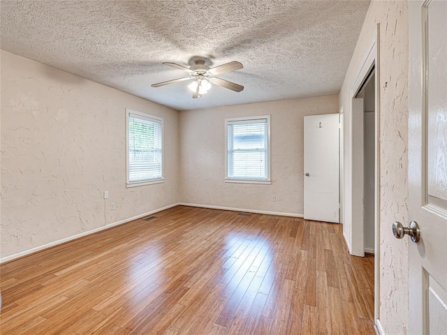 2429 Barclay Rd, Oklahoma City, OK 73120 - unfurnished room with light wood finished floors, a ceiling fan, a textured ceiling, and a textured wall