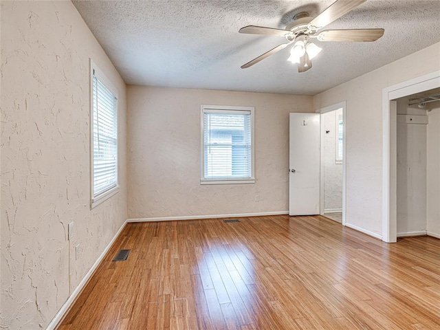 2429 Barclay Rd, Oklahoma City, OK 73120 - unfurnished bedroom featuring a textured wall, light wood-type flooring, a textured ceiling, and a ceiling fan