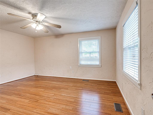 2429 Barclay Rd, Oklahoma City, OK 73120 - empty room featuring light wood finished floors, plenty of natural light, a textured ceiling, a textured wall, and ceiling fan