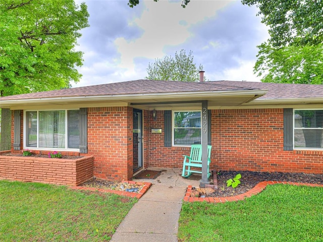 2429 Barclay Rd, Oklahoma City, OK 73120 - property entrance featuring brick siding, a lawn, and a porch