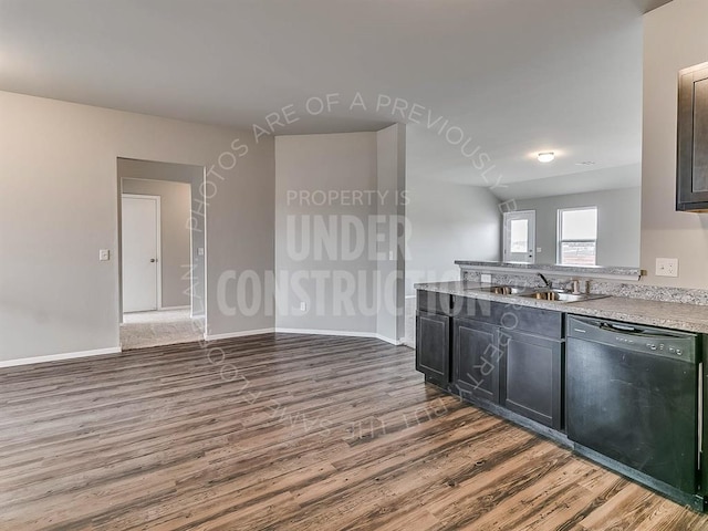 kitchen featuring baseboards, dark wood finished floors, a sink, and dishwasher
