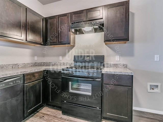 kitchen with dark brown cabinets, baseboards, under cabinet range hood, light wood finished floors, and black appliances