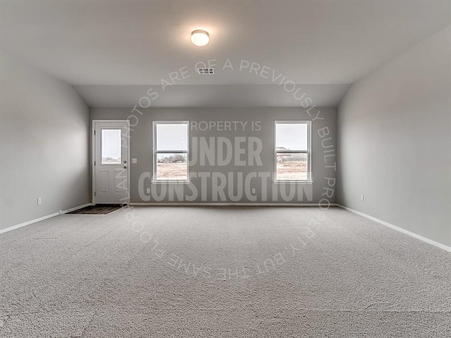 carpeted spare room featuring baseboards and visible vents