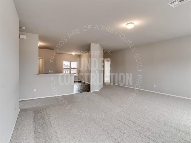 unfurnished living room featuring carpet floors, baseboards, and visible vents