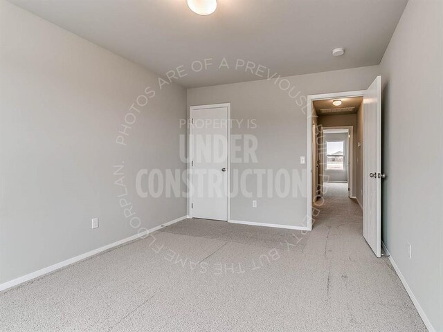 carpeted spare room featuring baseboards