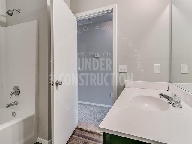 full bathroom with bathing tub / shower combination, baseboards, vanity, and wood finished floors