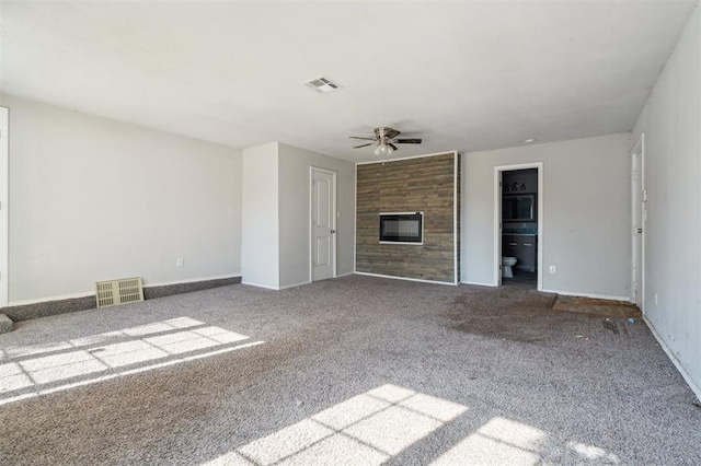 1662 NE 6th St, Moore, OK 73160 - unfurnished living room with ceiling fan, a glass covered fireplace, carpet flooring, and baseboards
