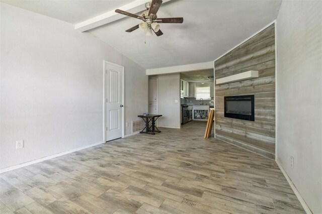 1662 NE 6th St, Moore, OK 73160 - unfurnished living room featuring a ceiling fan, a glass covered fireplace, wood finished floors, and baseboards