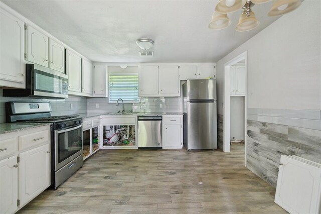 1662 NE 6th St, Moore, OK 73160 - kitchen with stainless steel appliances, a sink, white cabinetry, and light wood finished floors