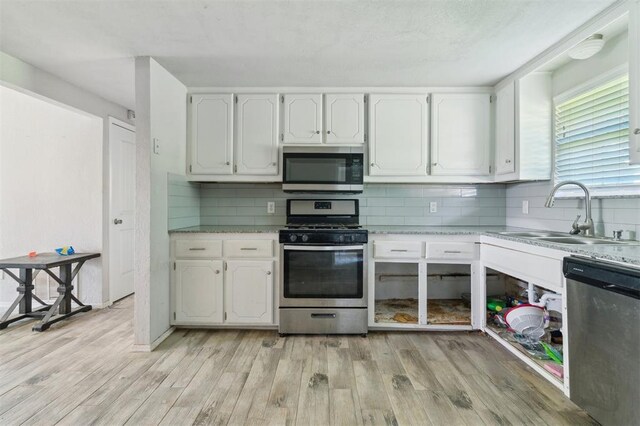 1662 NE 6th St, Moore, OK 73160 - kitchen featuring stainless steel appliances, a sink, light wood-style floors, white cabinets, and light countertops