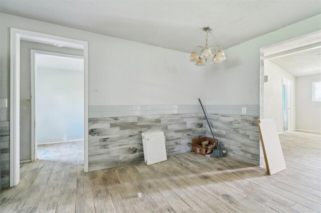 1662 NE 6th St, Moore, OK 73160 - unfurnished dining area with a chandelier, hardwood / wood-style flooring, and a wainscoted wall