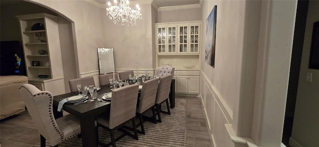 18812 Trailview Way, Edmond, OK 73012 - dining room featuring crown molding, arched walkways, dark wood finished floors, a notable chandelier, and a decorative wall