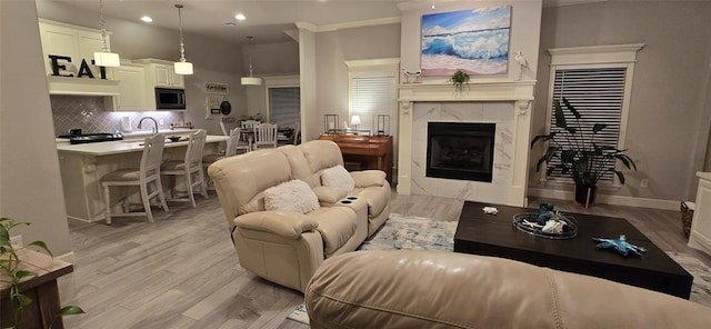 18812 Trailview Way, Edmond, OK 73012 - living room featuring crown molding, a fireplace, light wood-style floors, baseboards, and recessed lighting