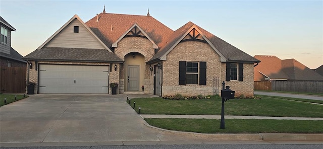 18812 Trailview Way, Edmond, OK 73012 - view of front facade with a front lawn, fence, stone siding, an attached garage, and driveway