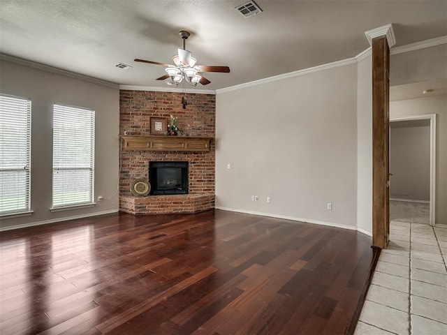 10812 S Miller Ave, Oklahoma City, OK 73170 - unfurnished living room with wood finished floors, a ceiling fan, crown molding, baseboards, and a brick fireplace