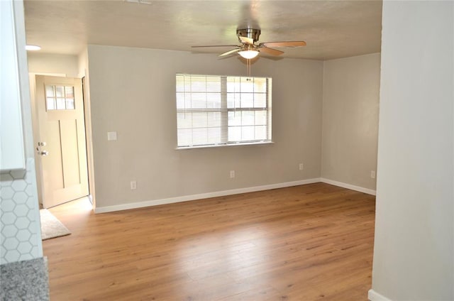 empty room featuring baseboards, ceiling fan, and wood finished floors
