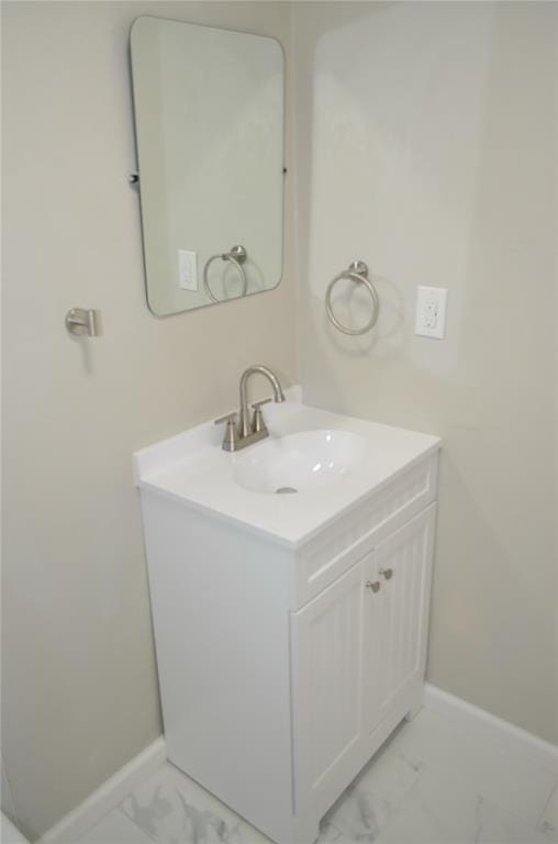 bathroom featuring baseboards, marble finish floor, and vanity