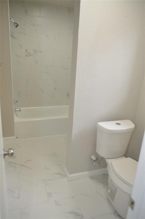 bathroom with toilet, baseboards, washtub / shower combination, and marble finish floor