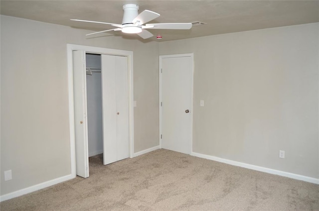 unfurnished bedroom featuring a ceiling fan, baseboards, carpet, and a closet