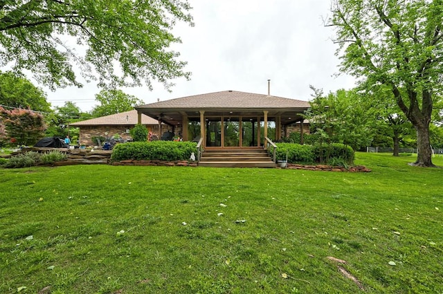 rear view of house featuring a yard