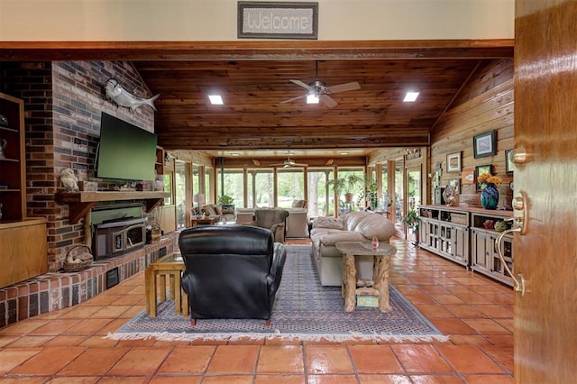 living area featuring a ceiling fan, a fireplace, wooden ceiling, and high vaulted ceiling