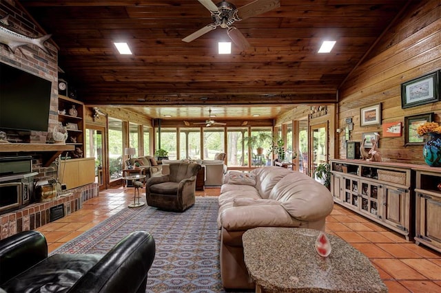 living area featuring tile patterned flooring, ceiling fan, lofted ceiling, and a wealth of natural light