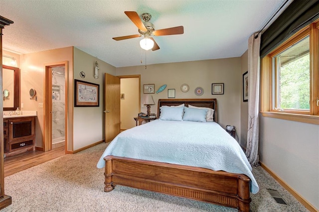 carpeted bedroom with baseboards, a ceiling fan, connected bathroom, and visible vents