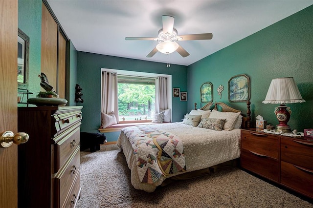 carpeted bedroom with a textured wall and ceiling fan
