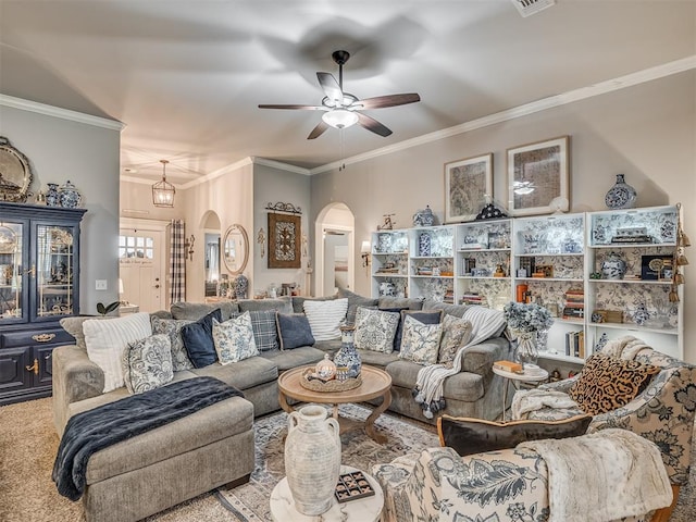 living area with arched walkways, a ceiling fan, and ornamental molding