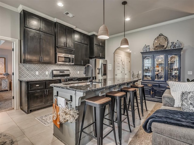 kitchen featuring stainless steel appliances, open floor plan, visible vents, and ornamental molding