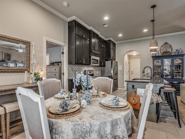 dining room with crown molding, arched walkways, visible vents, and recessed lighting