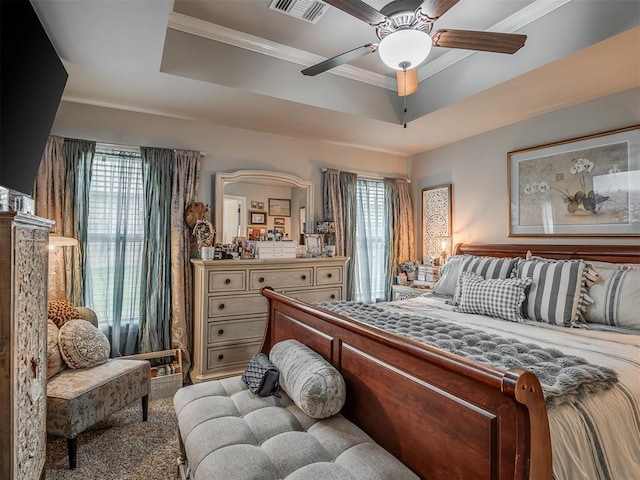 bedroom featuring visible vents, a raised ceiling, crown molding, and ceiling fan