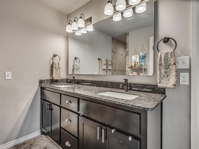 full bath featuring a sink, baseboards, double vanity, and visible vents